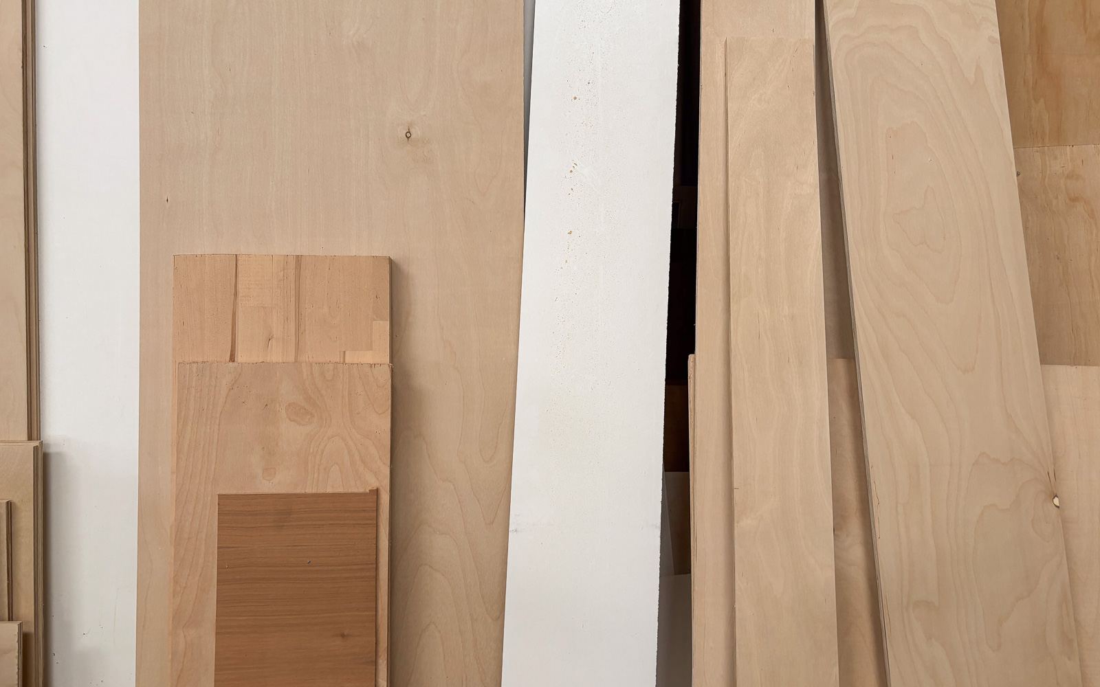 Sheets of furniture-grade birch plywood standing on edge, showing clean faces and layered edges